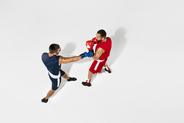 Image showing Two professional boxers boxing isolated on white studio background, action, top view