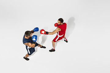 Image showing Two professional boxers boxing isolated on white studio background, action, top view