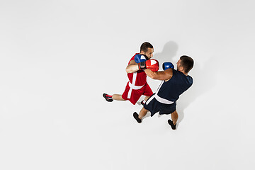 Image showing Two professional boxers boxing isolated on white studio background, action, top view