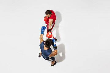 Image showing Two professional boxers boxing isolated on white studio background, action, top view