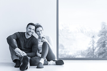 Image showing young couple sitting on the floor near window at home