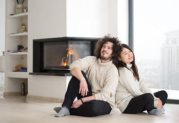 Image showing happy multiethnic couple  in front of fireplace