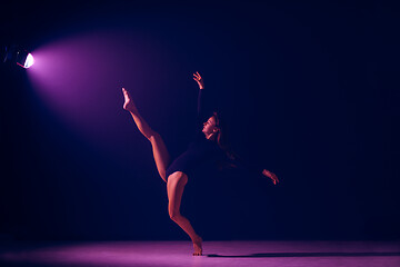 Image showing Young female ballet dancer on neon lights studio background.