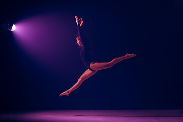 Image showing Young female ballet dancer on neon lights studio background.