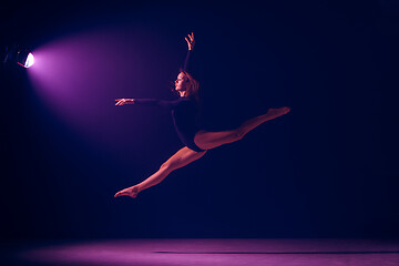 Image showing Young female ballet dancer on neon lights studio background.