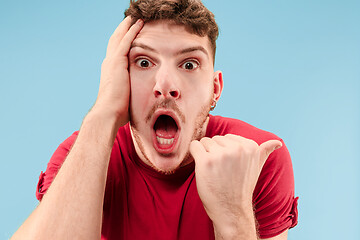 Image showing The young attractive man looking suprised isolated on blue