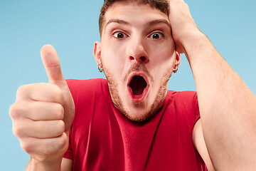 Image showing The young attractive man looking suprised isolated on blue