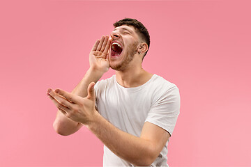 Image showing Isolated on pink young casual man shouting at studio