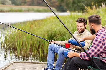 Image showing friends fishing and drinking tea from thermos