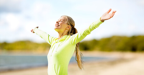 Image showing happy woman in sports clothes on beach