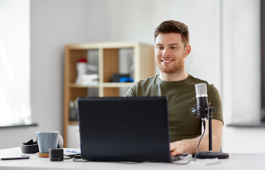 Image showing man with laptop and microphone at home office