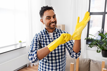 Image showing indian man putting protective rubber gloves on