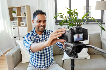 Image showing indian male video blogger adjusting camera at home