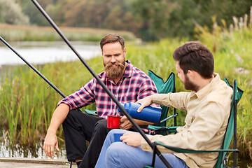 Image showing friends fishing and drinking tea from thermos