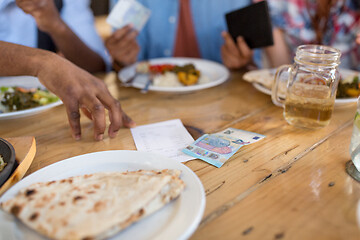 Image showing male hand with bill and money on restaurant table