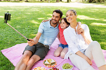 Image showing family having picnic and taking selfie at park