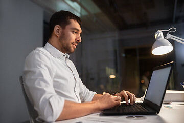 Image showing businessman with laptop working at night office