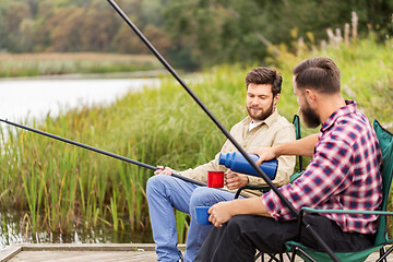 Image showing friends fishing and drinking tea from thermos