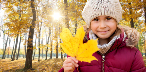 Image showing happy girl with fallen maple leaf at autumn park