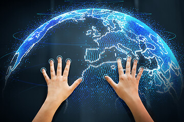 Image showing hands on touch screen with earth hologram