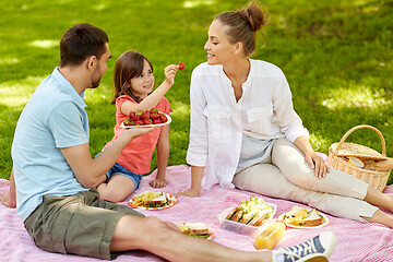 Image showing family eating strawberries on picnic at park