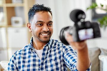 Image showing male video blogger with camera blogging at home