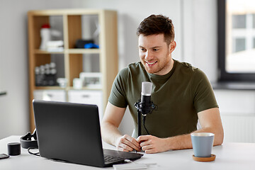 Image showing man with laptop and microphone at home office