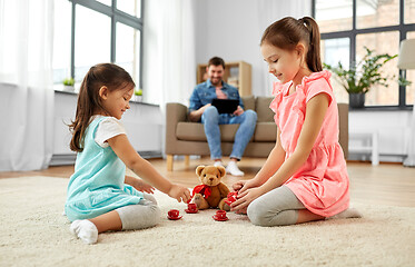 Image showing girls playing with toy crockery and teddy at home