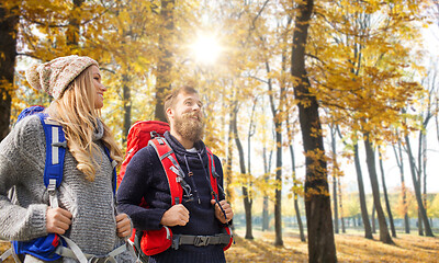 Image showing smiling couple with backpacks hiking in autumn