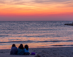 Image showing Three friends looking to the sunrise