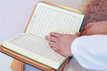 Image showing arabian muslim man reading Quran at home