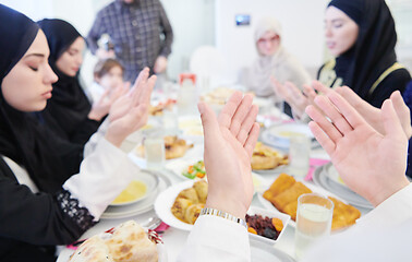 Image showing traditional muslim family praying before iftar dinner