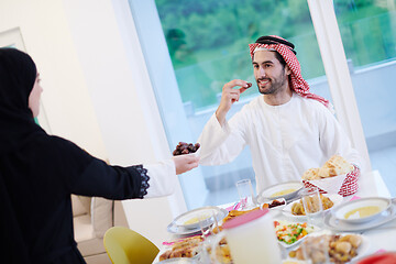 Image showing Muslim family having Iftar dinner eating dates to break feast