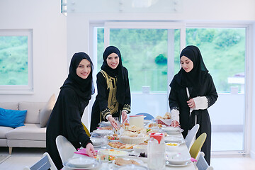 Image showing young muslim girls serving food on the table for iftar dinner