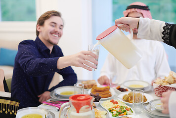 Image showing Muslim family having Iftar dinner drinking water to break feast