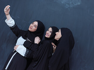 Image showing muslim women taking selfie picture in front of black chalkboard