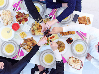 Image showing Muslim family having Iftar dinner eating dates to break feast