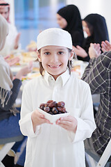 Image showing little muslim boy holding a plate full of sweet dates