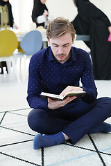 Image showing young muslim man reading Quran at home