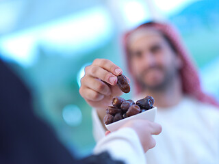 Image showing Muslim family having Iftar dinner eating dates to break feast