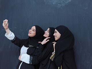 Image showing muslim women taking selfie picture in front of black chalkboard