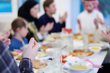 Image showing traditional muslim family praying before iftar dinner