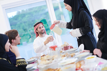 Image showing Muslim family having Iftar dinner drinking water to break feast