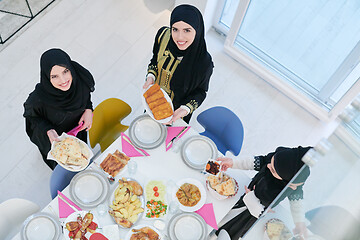 Image showing young muslim girls serving food on the table for iftar dinner to