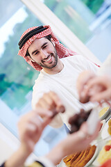 Image showing Muslim family having Iftar dinner eating dates to break feast