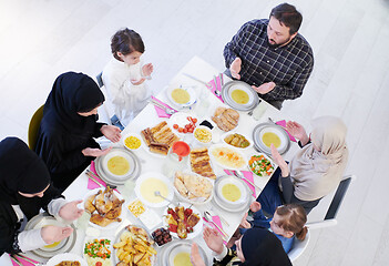 Image showing traditional muslim family praying before iftar dinner