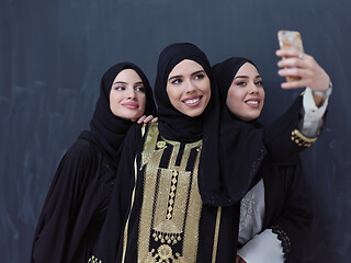 Image showing muslim women taking selfie picture in front of black chalkboard