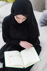 Image showing young muslim woman reading Quran at home