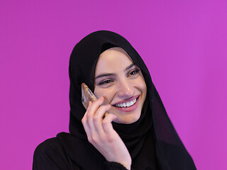 Image showing muslim business woman using smartphone on pink background