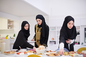 Image showing young muslim girls serving food on the table for iftar dinner